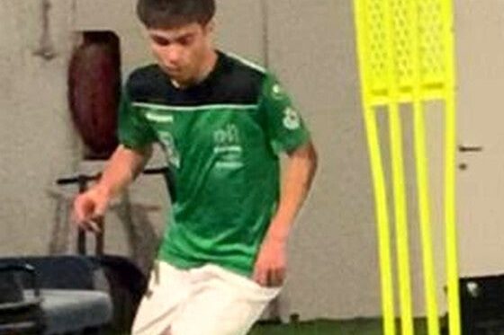 Young academy footballer in a fitness session on an artificial pitch, between the poles