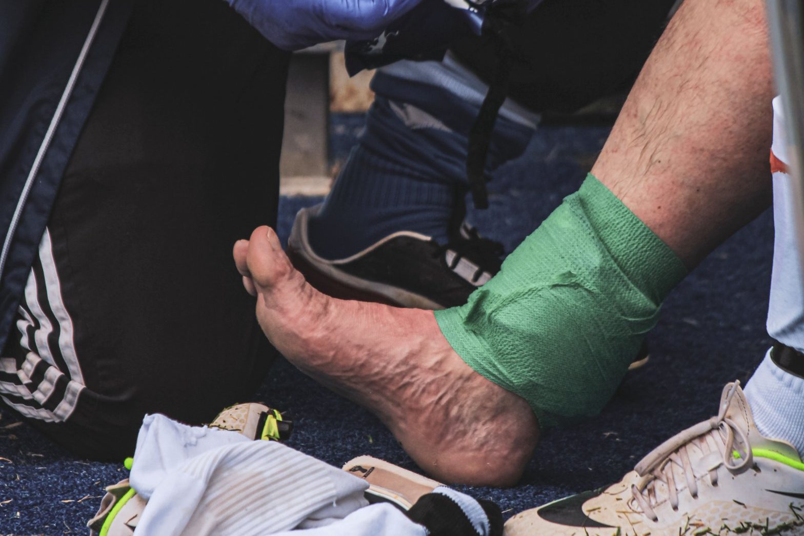 Ankle strapping on an injured footballer at the side of the pitch, nutrition and return to play
